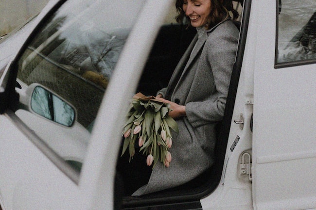 Frau steigt mit Straß Tulpen aus dem Auto