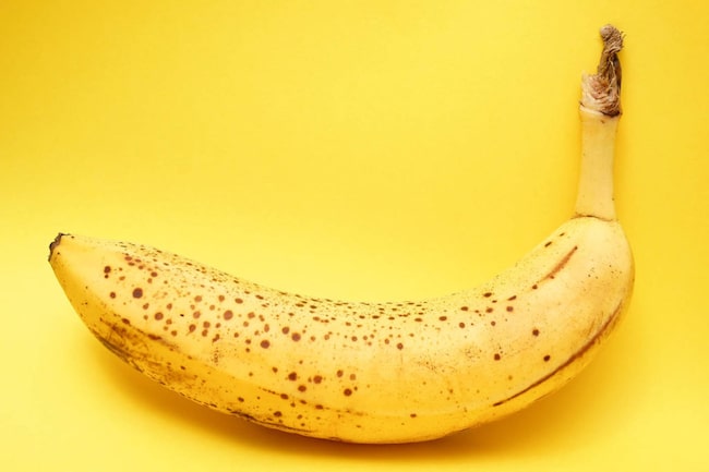 Reife Banane auf gelben Hintergrund