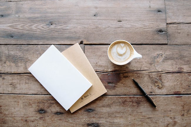 Notizblock, Stift und Kaffee auf einem Tisch