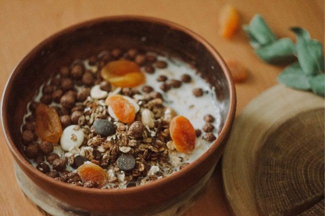 Müslie mit Trockenfrüchten und Milch in einer Schale