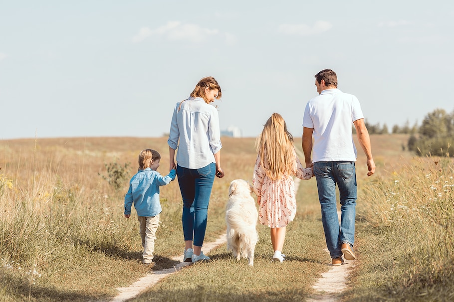 Eine Familie auf dem Feld mit 2 Kindern und ein Hund.