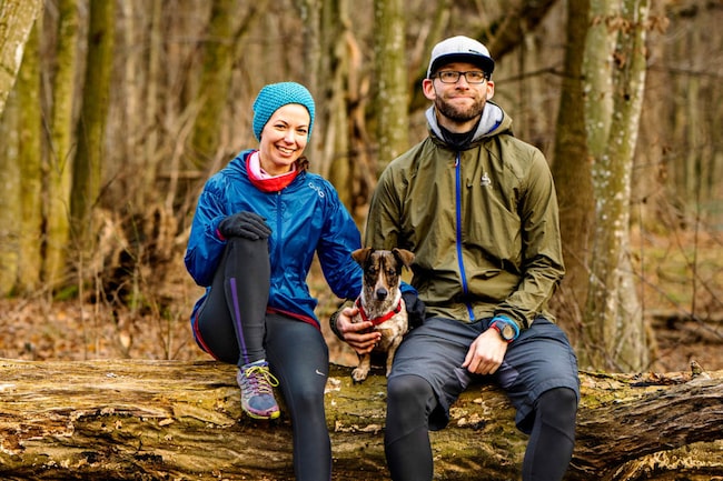 Mann und Frau sitzen mit Hund im Wald