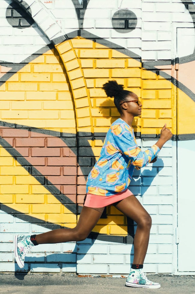 Frau läuft vor einer Graffitiwand