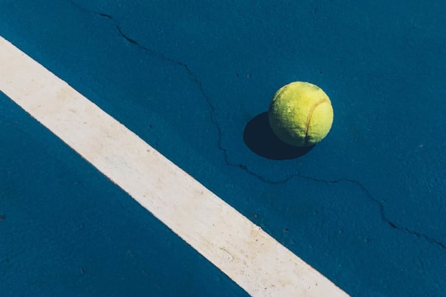 Tennisball liegt auf einem Tennisplatz