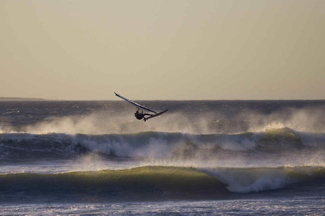 Windsurfer fliegt am Meer durch die Luft
