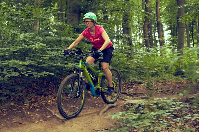 Frau fährt auf einem Mountainbike im Wald