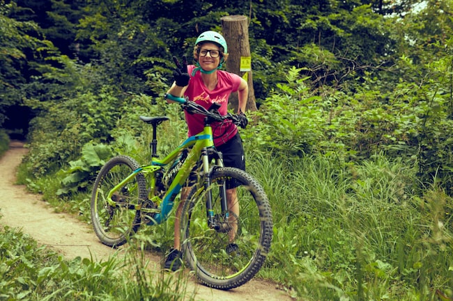 Frau mit Mountainbike auf einem Waldweg