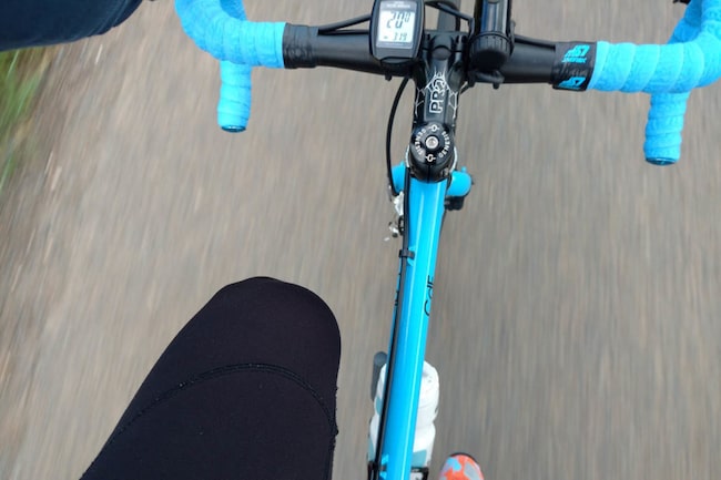 Blaues Rennrad während der Fahrt von oben