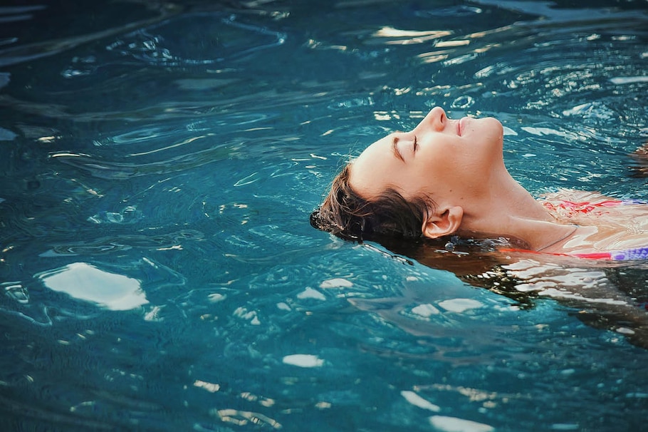 Frau schwimmt am Rücken in einem Schwefelbad
