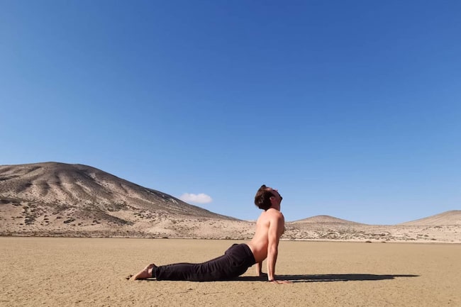 Mann macht in der Wüste eine Yogaübung