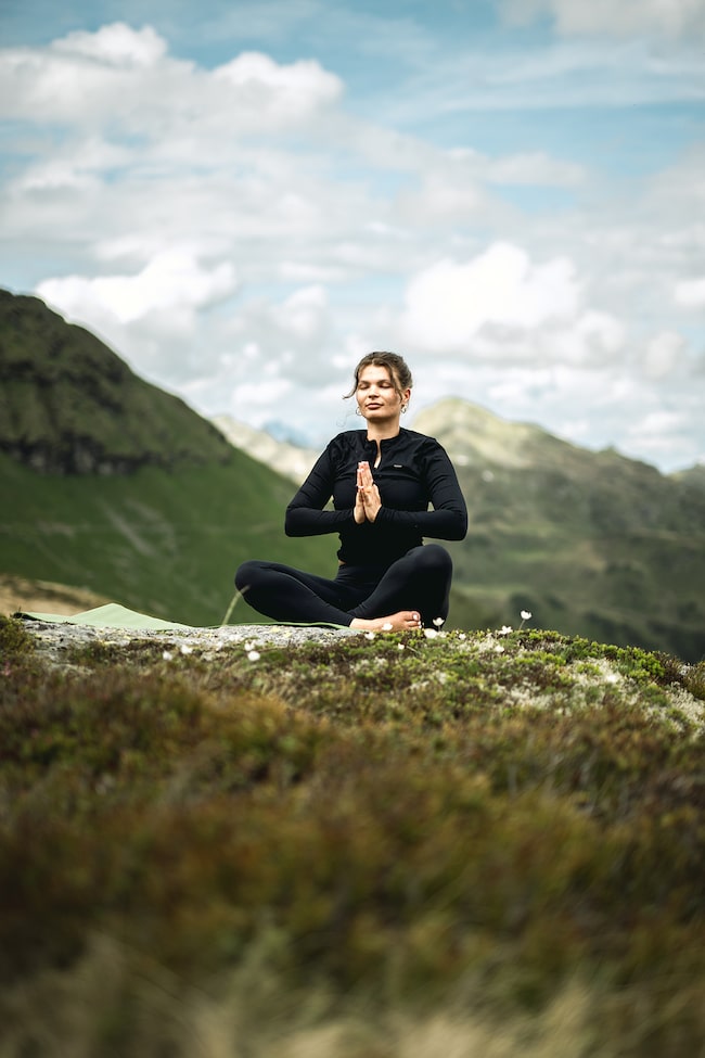 Achtsamkeit inmitten der Alpen: Beim HIGHLANDER findet man Ruhe und Fokus beim Meditieren in der Natur.