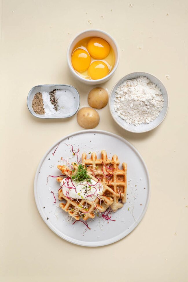 Pikante Waffeln auf einem Teller, daneben stehen die Zutaten