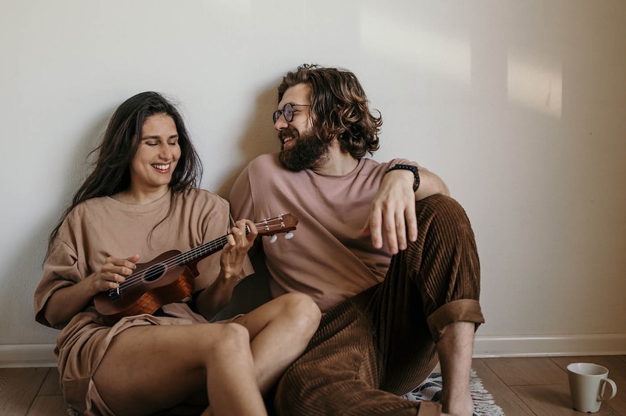 Paar sitzt am Boden und macht entspannt Musik