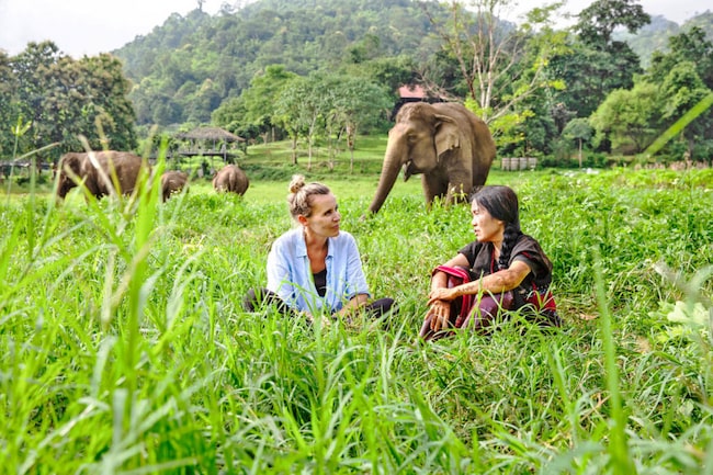 Waltraud mit Lek Chailert sitzend bei den Elefanten