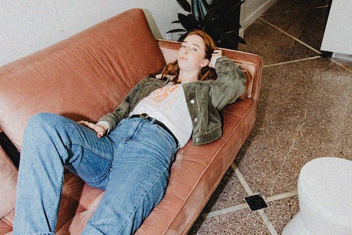 Mädchen liegt auf Couch. (Bild: Parker Whitson/Unsplash)