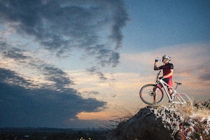 Radfahrer trinkt bei Sonnenuntergang Wasser