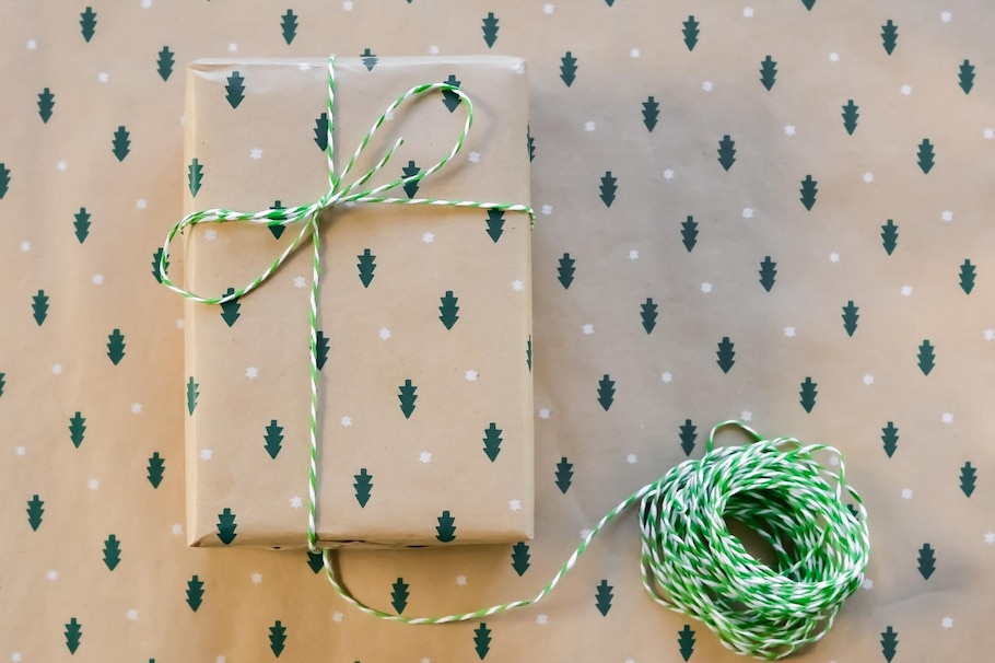 Was kann man Mutter zu Weihnachten schenken? Packerl schön eingepackt in Packpapier mit Tannenbäumen als Weihnachtsgeschenk für Eltern