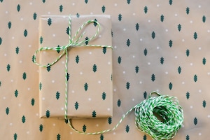 Was kann man Mutter zu Weihnachten schenken? Packerl schön eingepackt in Packpapier mit Tannenbäumen als Weihnachtsgeschenk für Eltern