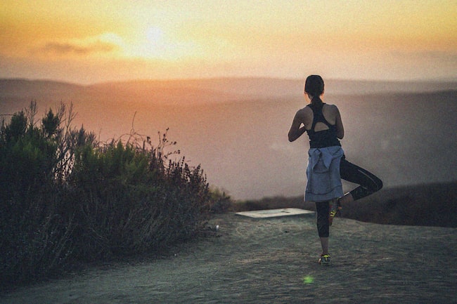 Frauh dehnt sich nach Joggen bei Sonnenuntergang