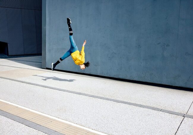 Parkour, Athletin, Frau, Drehung in der Luft ohne Hände