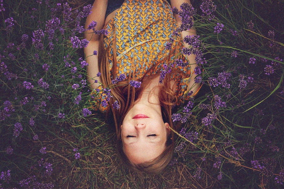 Junge Frau liegt in Blumenwiese