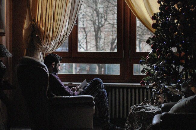 Mann liest am Fenster, Christbaum