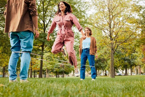 zwei Frauen, ein Mann, Park, Wiese, Bäume, Herbst, Gummihüpfen, Outdoorspiele, Bewegung, Sport, Spaß, carpe diem