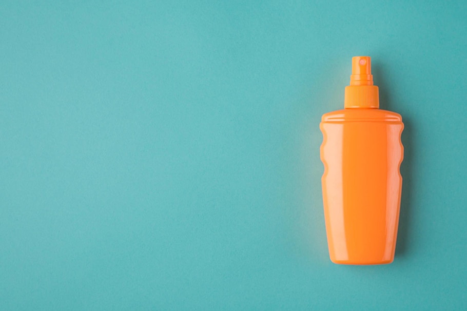 türkiser Hintergrund, orange Sonnencremeflasche, Pumpflasche, Sonnencreme