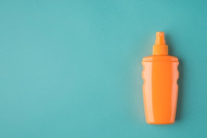 türkiser Hintergrund, orange Sonnencremeflasche, Pumpflasche, Sonnencreme
