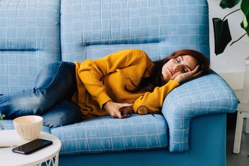 Powernap, schlafende Frau am Sofa, blaues Sofa, Wohnzimmer
