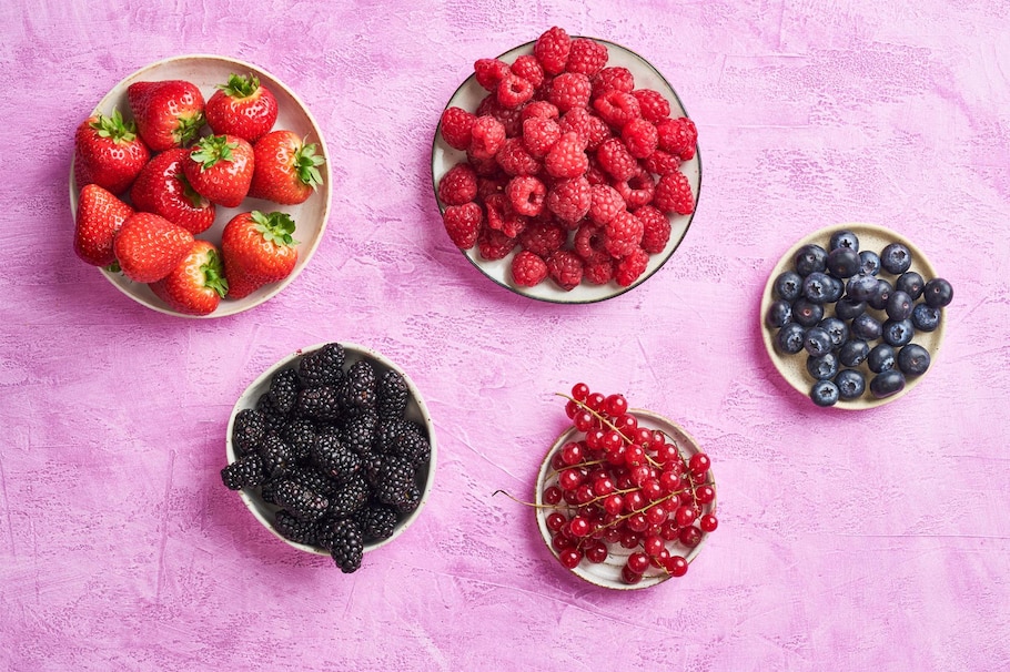 Erdbeeren, Himbeeren, Brombeeren, Heidelbeeren, rote Ribisel, lila Hintergrund, Teller
