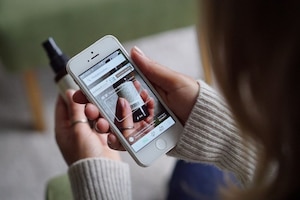 Frauenhände mit Handy, auf der gerade die Codecheck-App ein Produkt scannt.