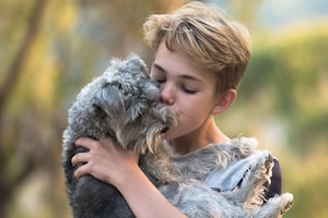 Junge küsst Hund - große Liebe zwischen Kind und Haustier