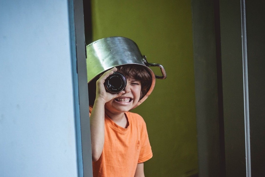 Kinderwitze machen kreativ: Junge, verkleidet als Pirat mit Topf am Kopf und Glas als Fernrohr