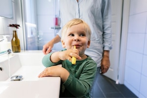 Bub, Junge, Zähneputzen, Badezimmer, Mutter im Hintergrund
