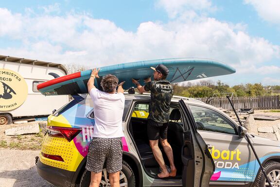 Karl und Pascal schnallen das Board auf den Dachträger des Škoda Kodiaq bevor sich die beiden Moderatoren und DJs wieder an die Arbeit machen.