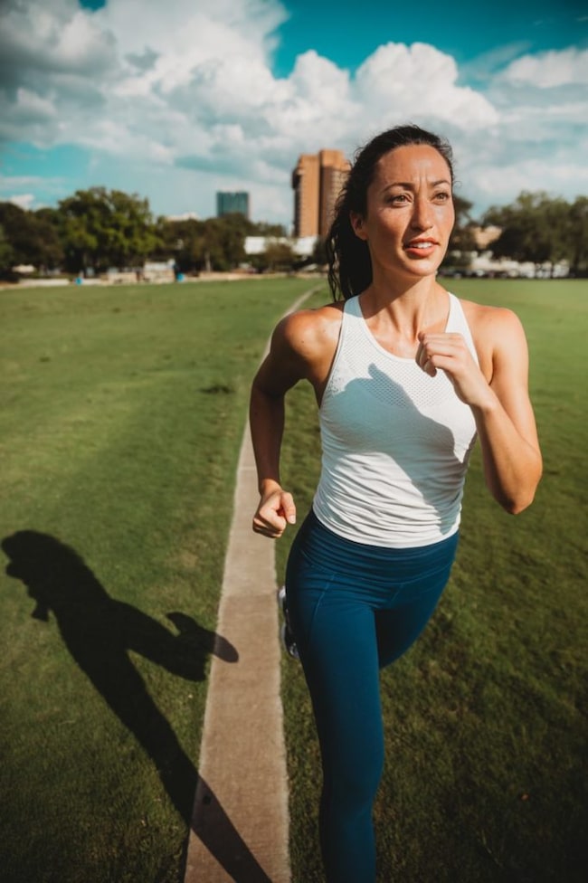 Junge Frau läuft auf Sportplatz