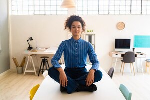 Frau, Büro, am Tisch sitzend, meditiert