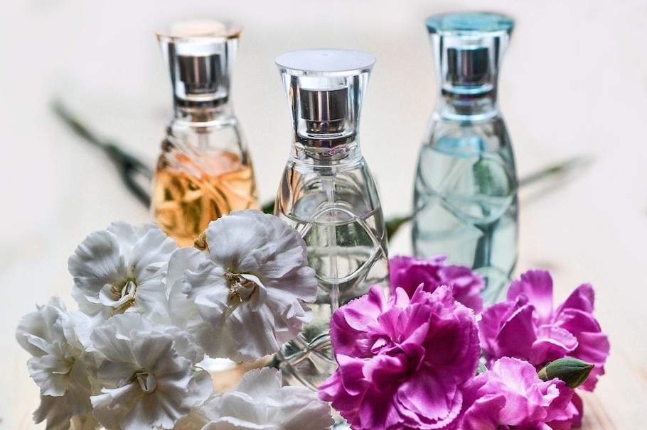 Drei Parfumflakons mit Rosenblättern davor - welches Parfum passt zu mir?