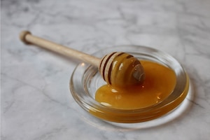 Manuka-Honig in Glassschale mit Honigrührstab