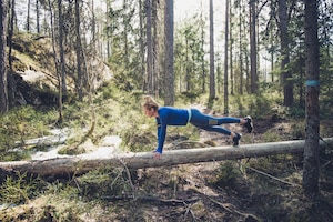 Frau macht Plank im Wald