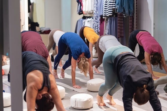 mehrere personen machen den herabschauenden hund