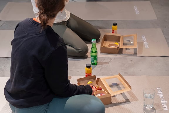 zwei frauen essen ihr frühstück auf den yoga matten