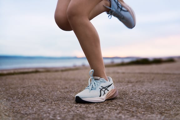 Frauenbeine in Detailaufnahme. ASICS Laufschuhe im Fokus.