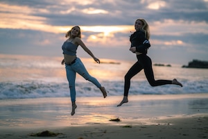 Zwei junge Frauen haben Freude am Laufen am Strand