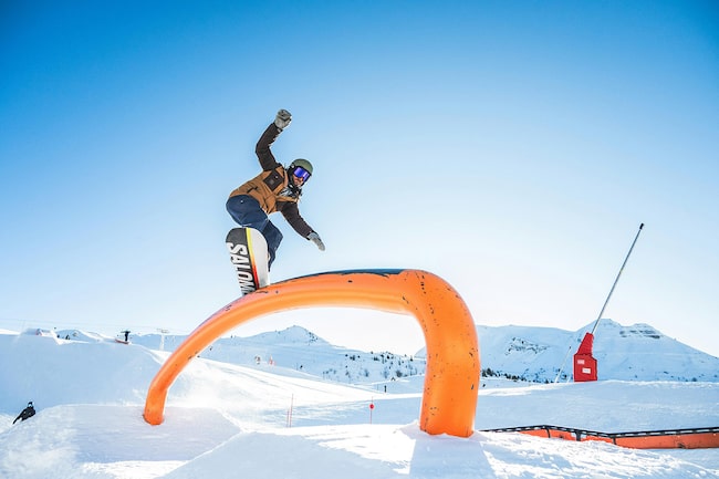 Ein Snowboarder in einem Funpark.