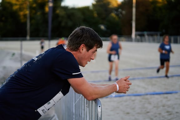 Ein Läufer des POWER RUNs lehnt sich an einem Geländer an.