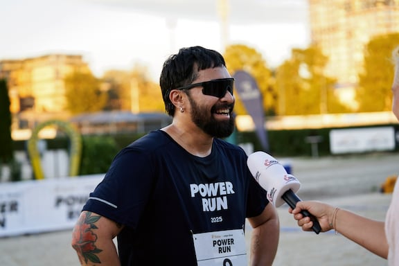 Ein Teilnehmer des POWER RUN wird von einer Journalistin interviewt.