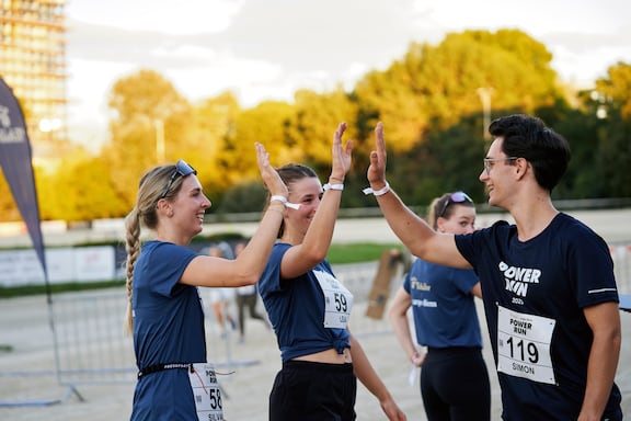 Teilnehmerinnen und Teilnehmer des POWER RUN klatschen sich in die Hände.