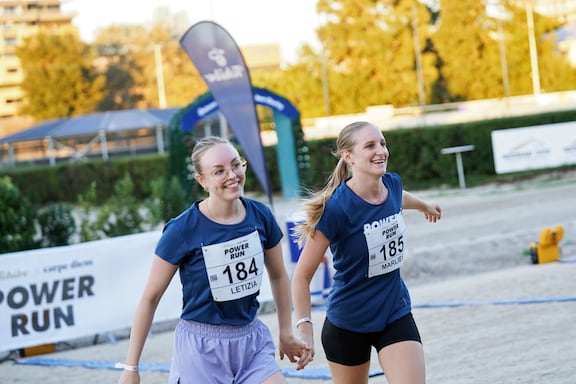 Zwei Teilnehmerinnen laufen Hand in Hand beim POWER RUN.